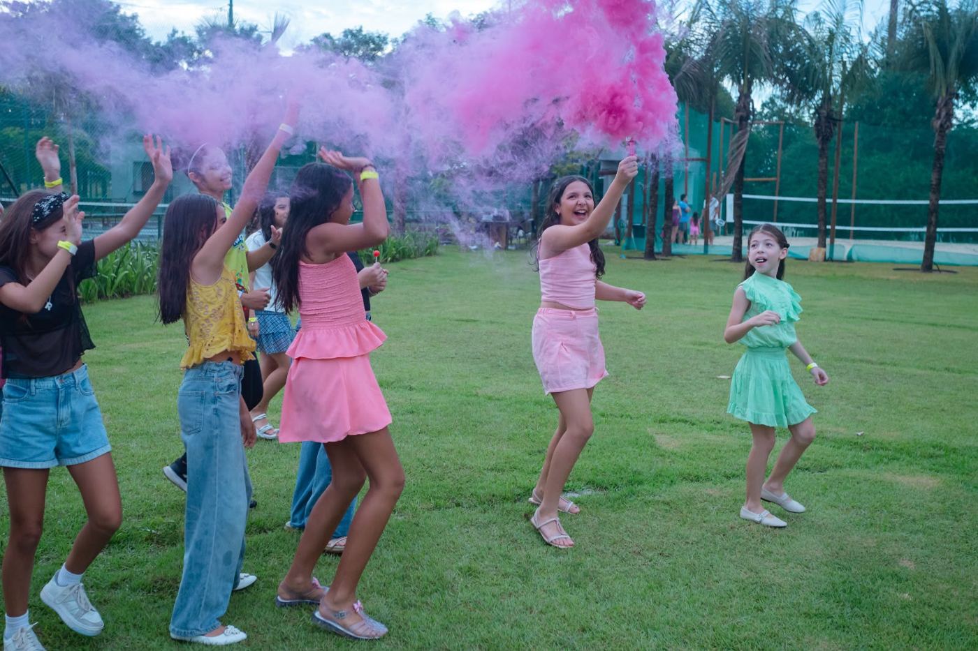 Crianças dançando com fumaça colorida rosa