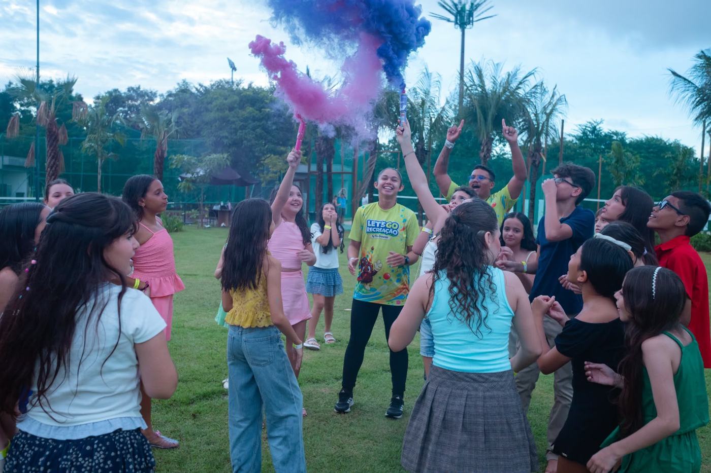 Crianças em evento ao ar livre com fumaça colorida