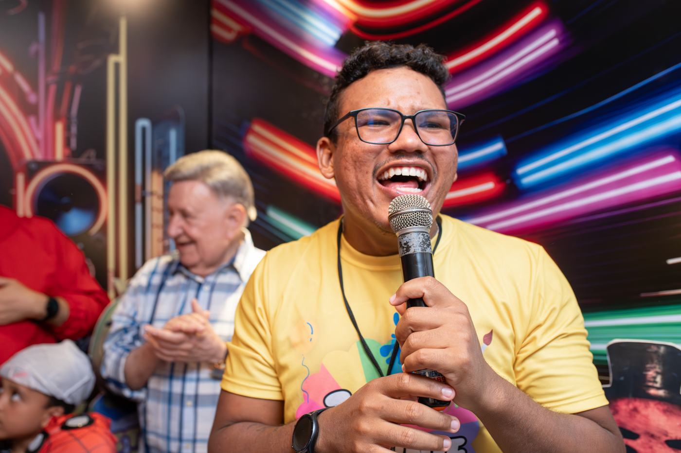 Tio Brownie animando uma festa com microfone na mão