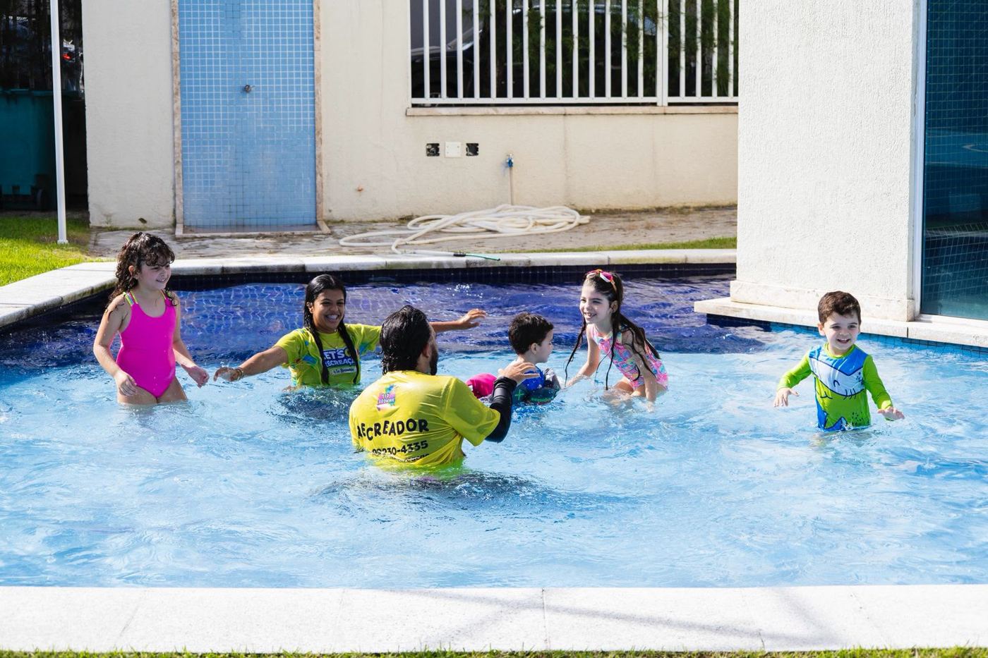 Recreadores da Let's Go brincando com crianças dentro da piscina